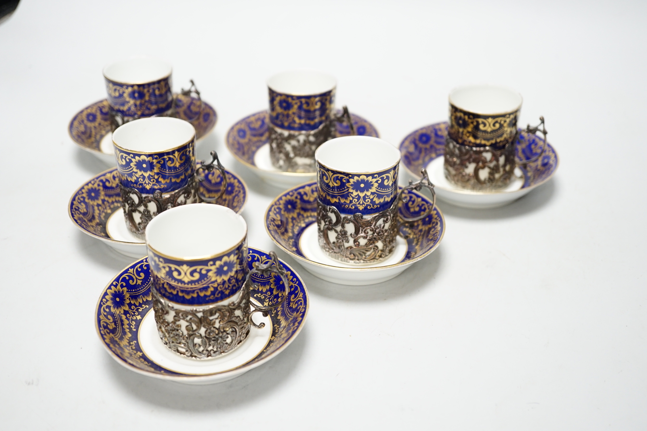 A set of six silver jacketed porcelain cups and saucers